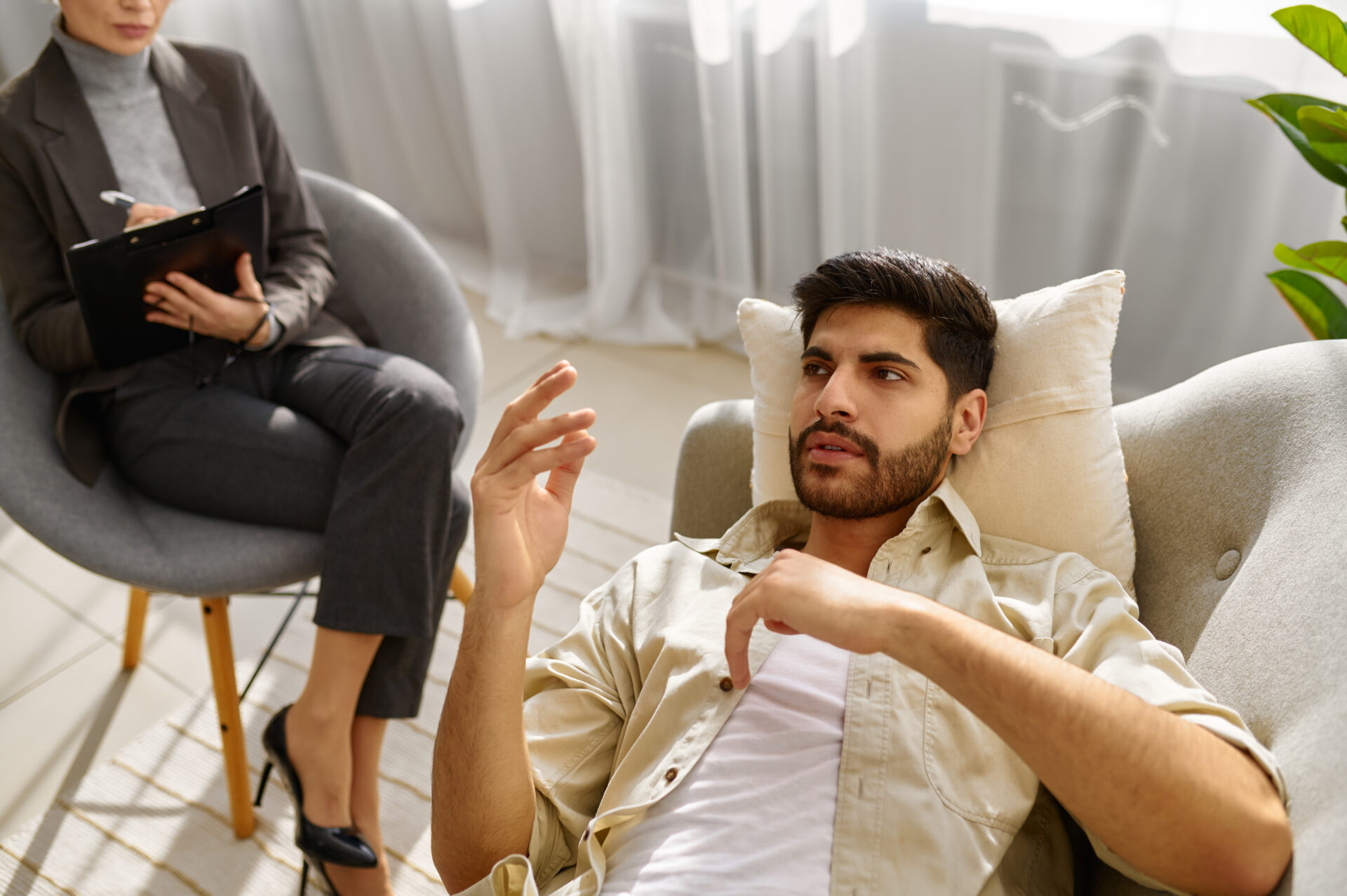 Female psychologist working with man on couch